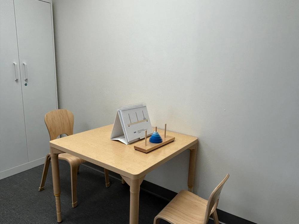 Child-friendly testing room for pediatric neuropsychological assessments with wooden table and assessment materials