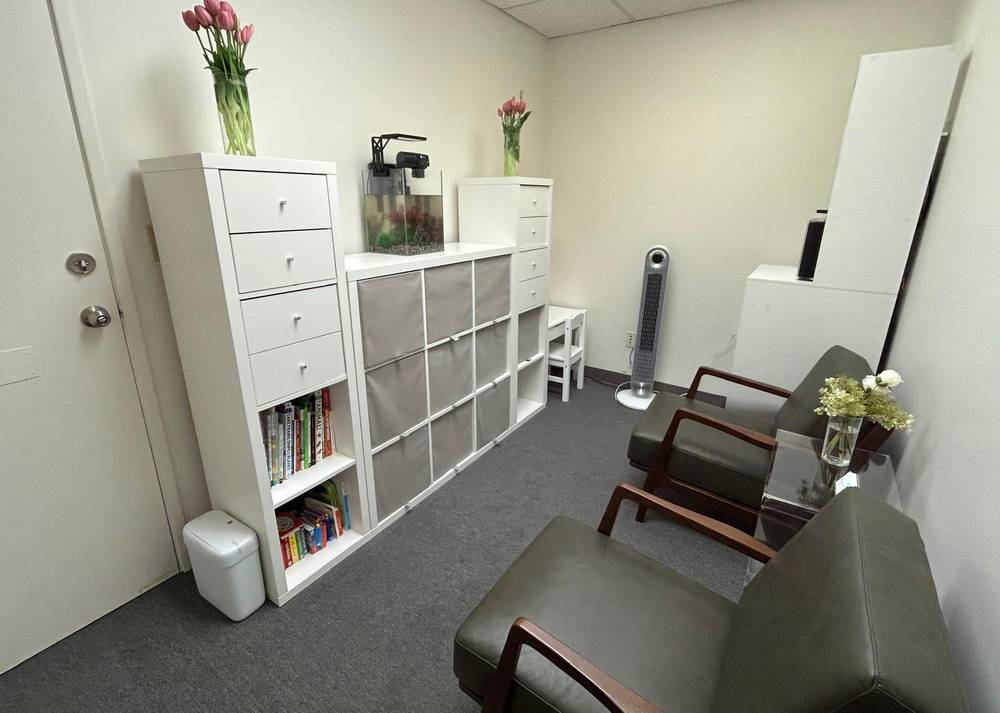 Welcoming waiting room for children and adolescents at Pediatric Neuropsychology Associates with comfortable seating, bookshelf, fish tank, and fresh flowers